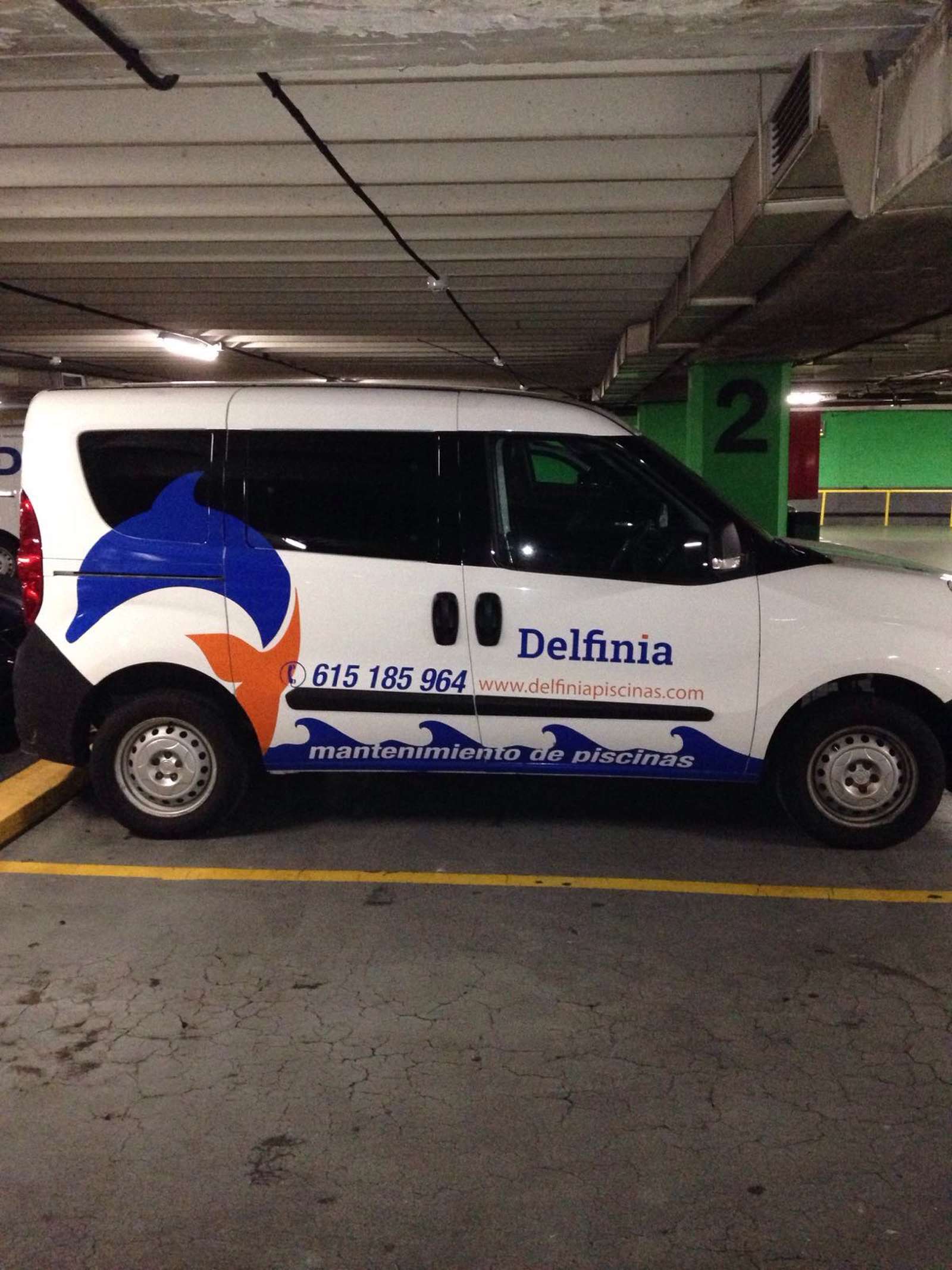 Furgoneta de Delfinia rotulada con el delfín, el teléfono y olas azules